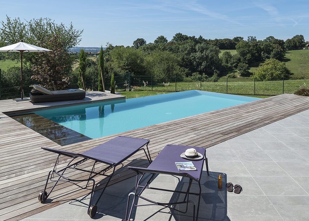 Piscine avec liner gris clair et margelles en pierres Prieuré