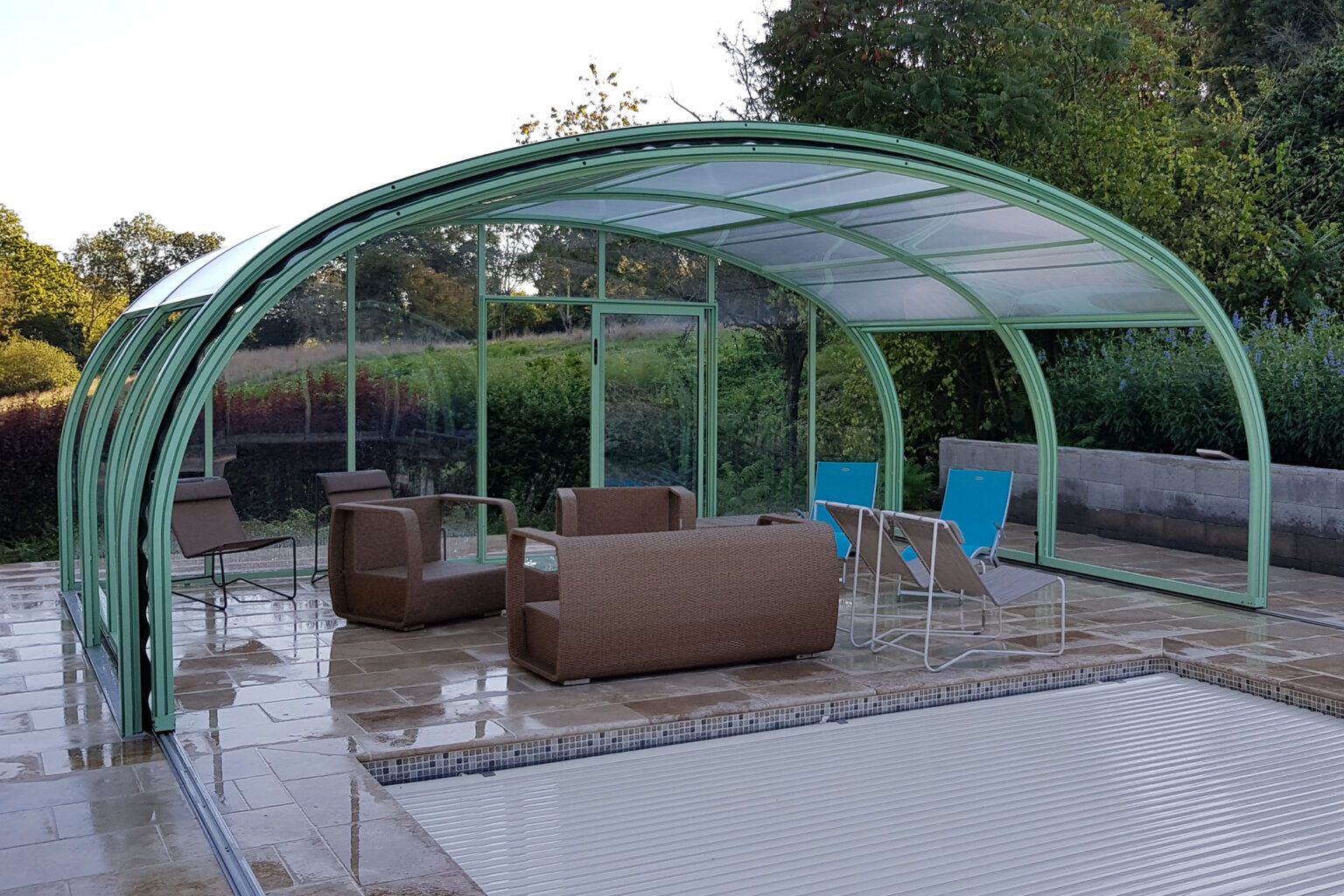 Abri haut de piscine avec salon de jardin