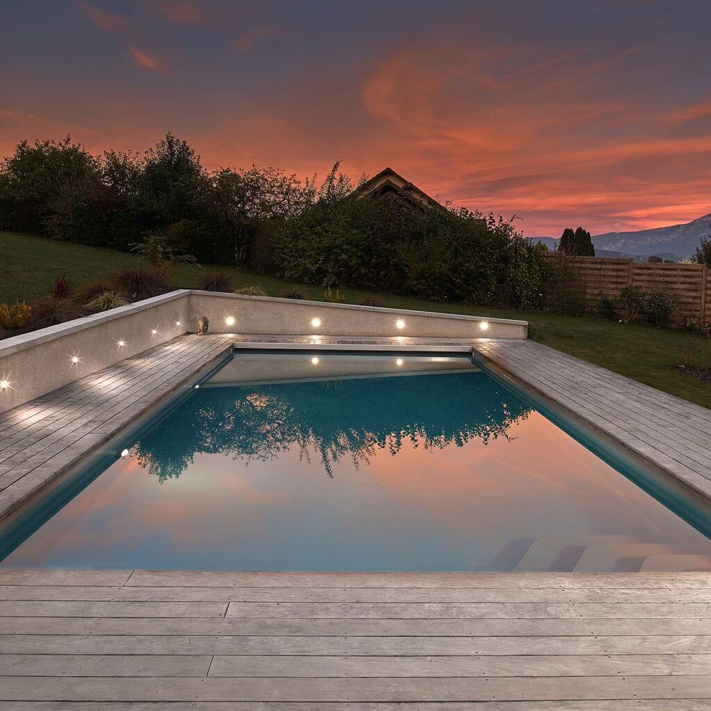 Piscine extérieure de 11 x 4.5 m avec spot leds et plage en bois exotique