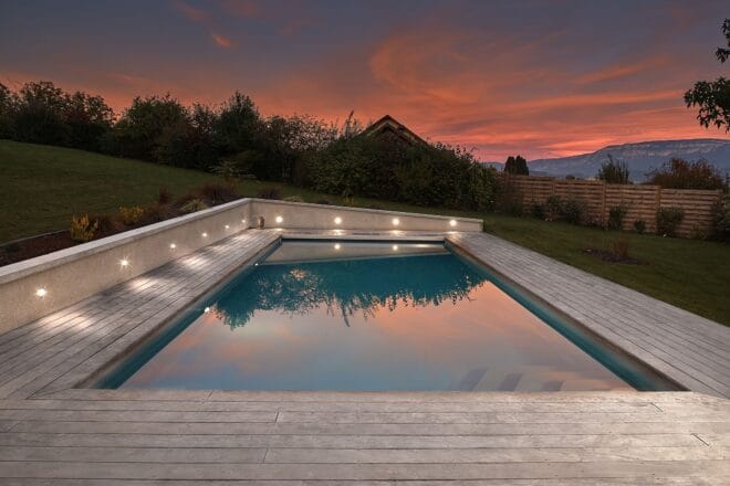 Piscine extérieure de 11 x 4.5 m avec spot leds et plage en bois exotique