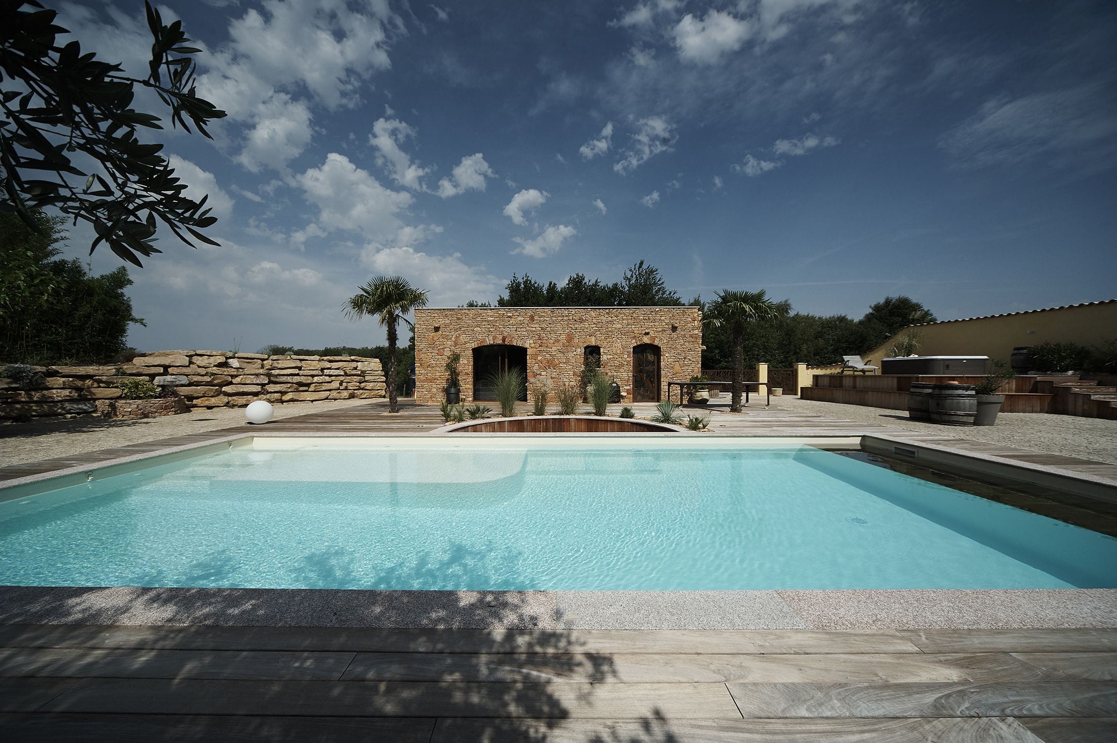 Piscine lagon de luxe avec plage immergée et ambiance paysagère naturelle