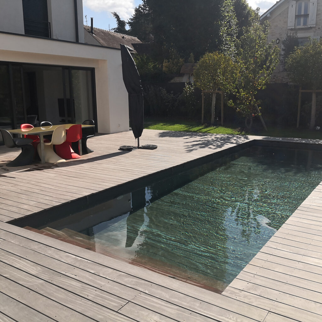 Piscine extérieure avec plage en bois et fond mobile