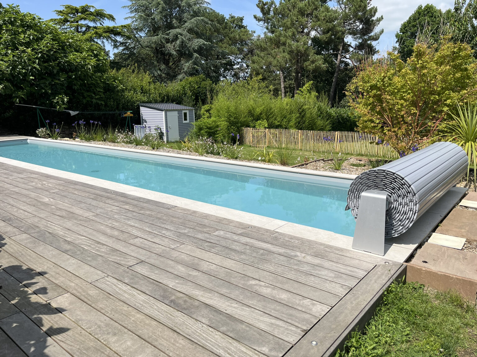 Piscine extérieure avec margelles grès cérame et plage en bois