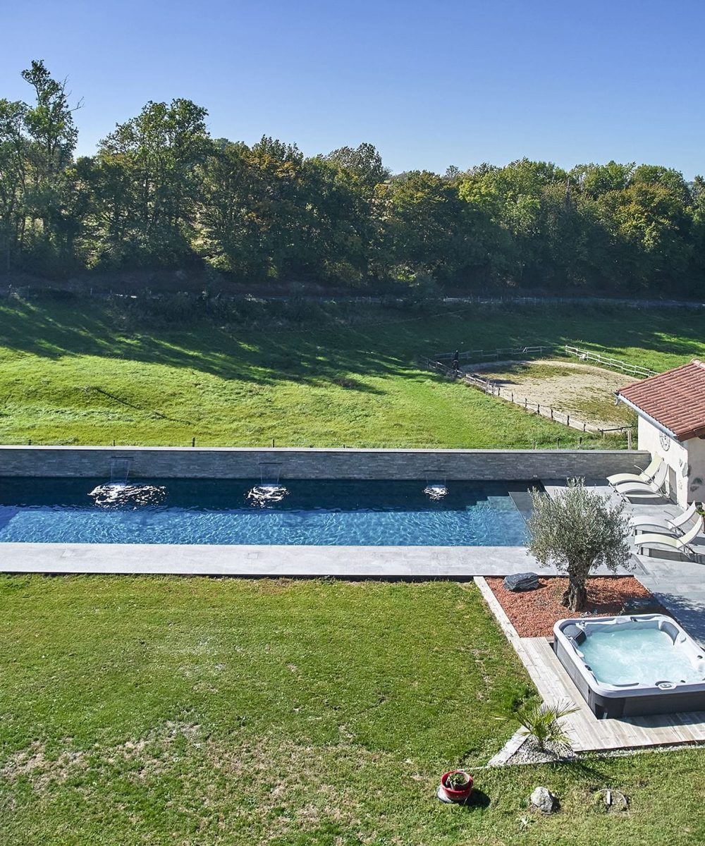 Couloir de Nage avec spa semi-encastré, margelles et plage en bois exotique